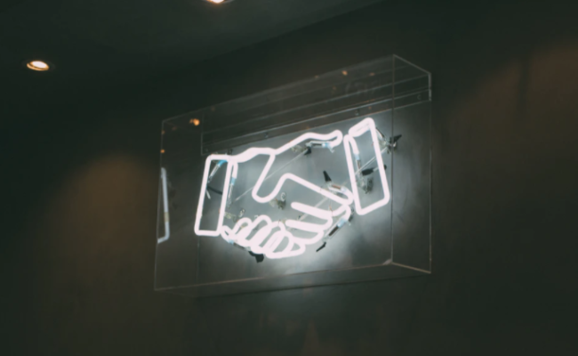 Neon sign of hand shake