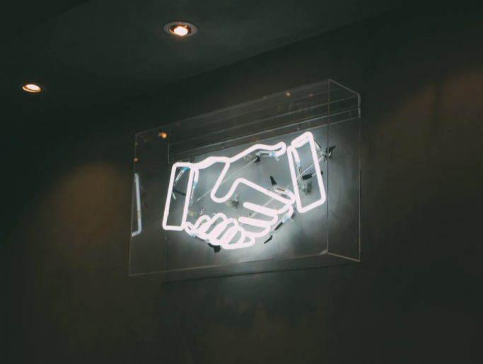 Neon sign of hand shake